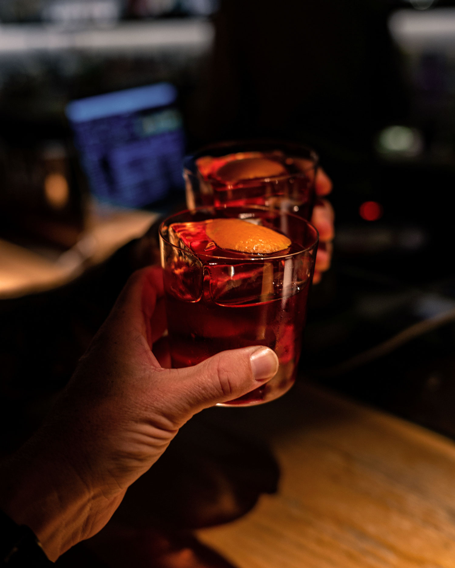 Zwei Gläser Negroni stoßen in einer eleganten Bar in Brera, Mailand, an – Symbol für Geselligkeit, italienische Aperitivo-Kultur und die zeitlose Faszination dieses ikonischen Cocktails.