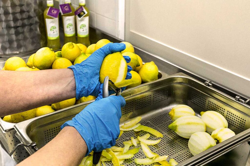 Ein Mitarbeiter des Caputo Limoncello-Herstellers schält Zitronen von Hand, um die Zutaten für die Limoncello-Produktion vorzubereiten