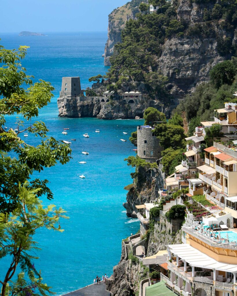 Blick auf die malerische Amalfiküste in Italien mit türkisblauem Wasser und Felsenhäusern, ein typischer Ort, an dem Limoncello aus Zitronen der Region hergestellt wird