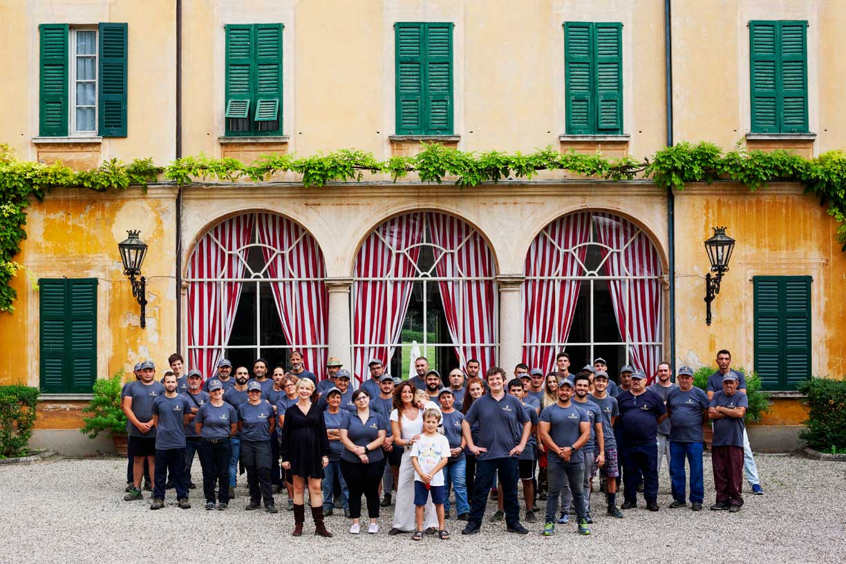 Ein Gruppenfoto des gesamten Teams des Weinguts Conte Vistarino, die vor dem historischen Gebäude des Weinguts stehen