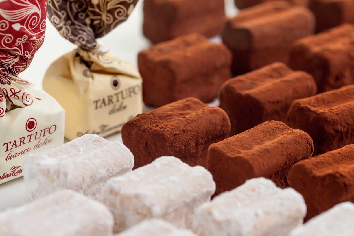 Eine Auswahl an handgefertigten Tartufi-Pralinen von Antica Torroneria Piemontese. Die Pralinen sind in Kakao oder Puderzucker gehüllt und in ansprechendem Verpackungspapier gewickelt