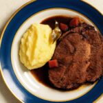 Zartes Brasato al Barolo mit cremigem Kartoffelpüree, angerichtet auf elegantem Porzellan, verfeinert mit Rotweinsauce – piemontesische Spezialität aus Rindfleisch und Barolo-Wein.