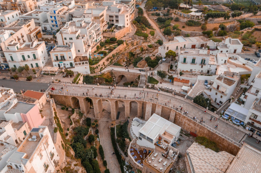 Luftaufnahme von Polignano a Mare in Apulien mit Brücke und Altstadt, Herzstück der Region des Primitivo-Weins.