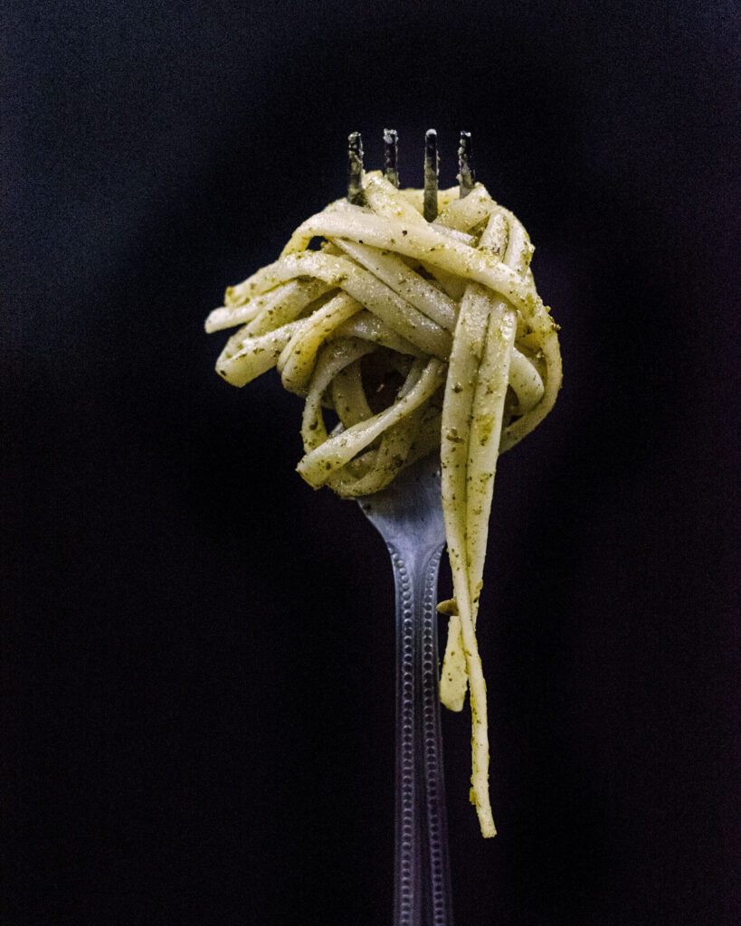 Eine Gabel voll Linguine mit original Pesto alla Genovese – cremig, würzig, authentisch ligurisch.