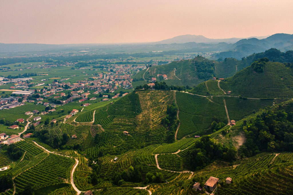 Panorama der steilen Weinberge rund um Valdobbiadene mit Blick auf das umliegende Dorf – Heimat des besten Prosecco.