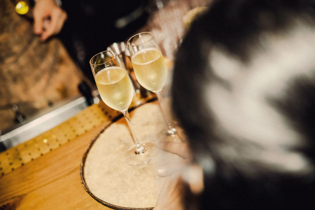 Zwei Gläser Prosecco werden an einer Bar serviert – prickelnde Eleganz für den perfekten Aperitivo-Moment.