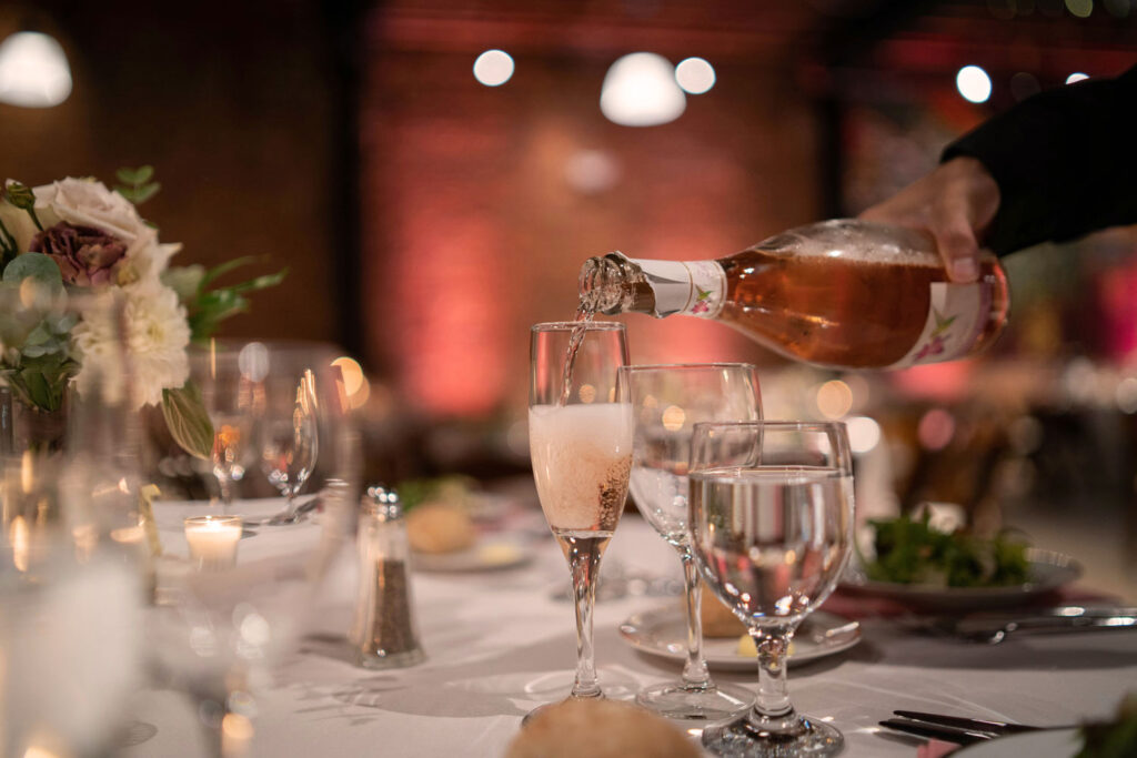 Prosecco Rosé wird bei einer eleganten Abendveranstaltung in ein Glas eingeschenkt – festliche Stimmung mit italienischem Flair.
