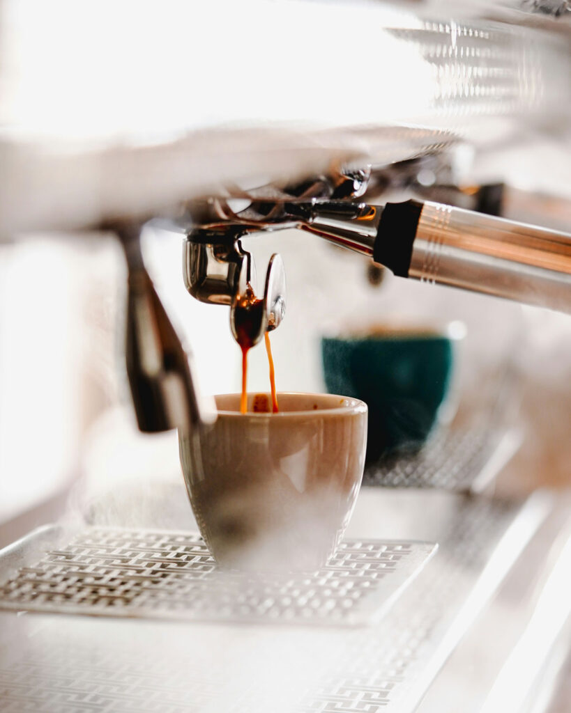 Frischer Espresso fließt aus einer professionellen Siebträgermaschine in eine Tasse – die Basis eines echten Cappuccino.
