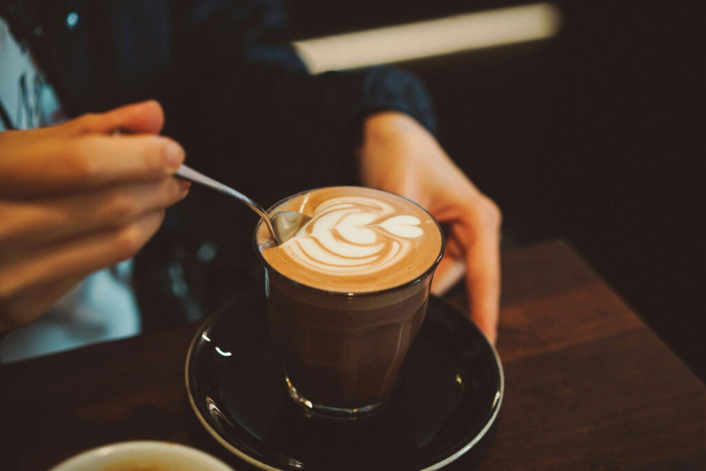 Nahaufnahme eines Cappuccino mit Latte Art in Herzform, bereit zum Genießen in einem Café.
