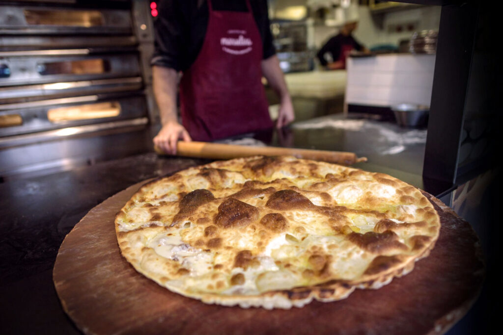 Frisch gebackene Focaccia di Recco mit goldbrauner Kruste direkt aus dem Ofen einer italienischen Bäckerei.