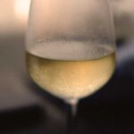 Makroaufnahme eines beschlagenen Weißweinglases mit Gavi-Wein, perfekt gekühlt für den sommerlichen Weingenuss.
