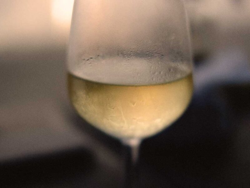 Makroaufnahme eines beschlagenen Weißweinglases mit Gavi-Wein, perfekt gekühlt für den sommerlichen Weingenuss.
