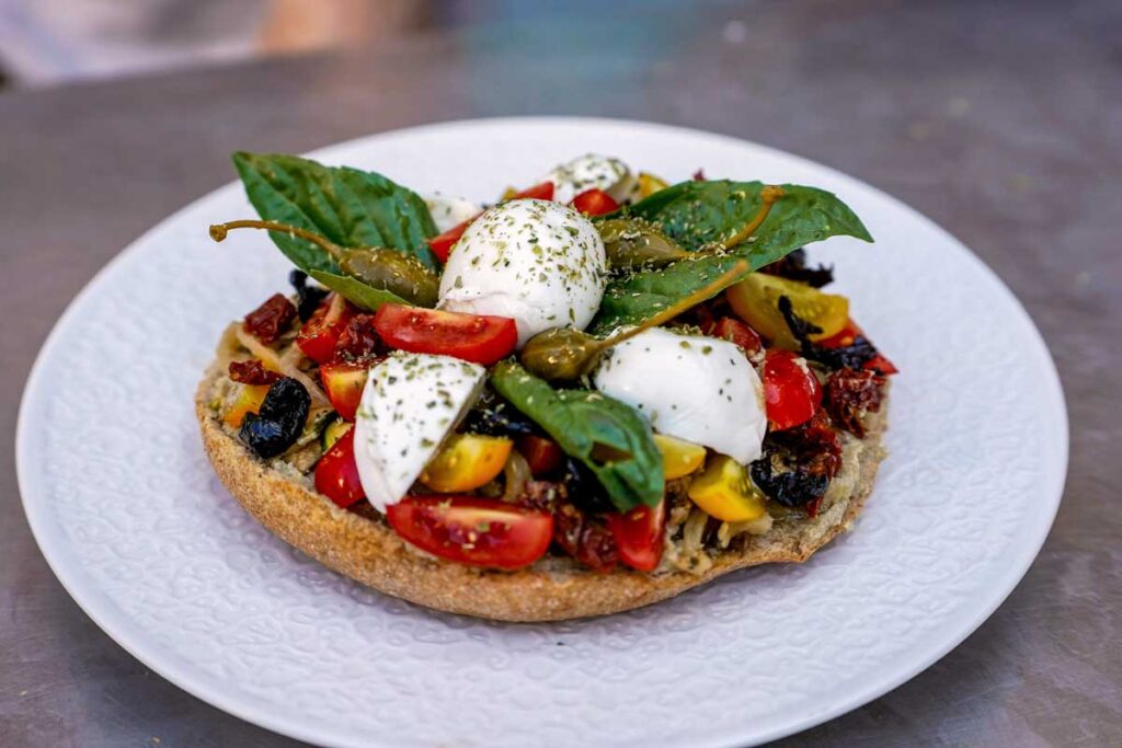 Mediterrane Bruschetta mit frischem Mozzarella di Bufala, Tomaten, Basilikum und Oliven – perfekte Kombination für Mozzarella-Liebhaber.