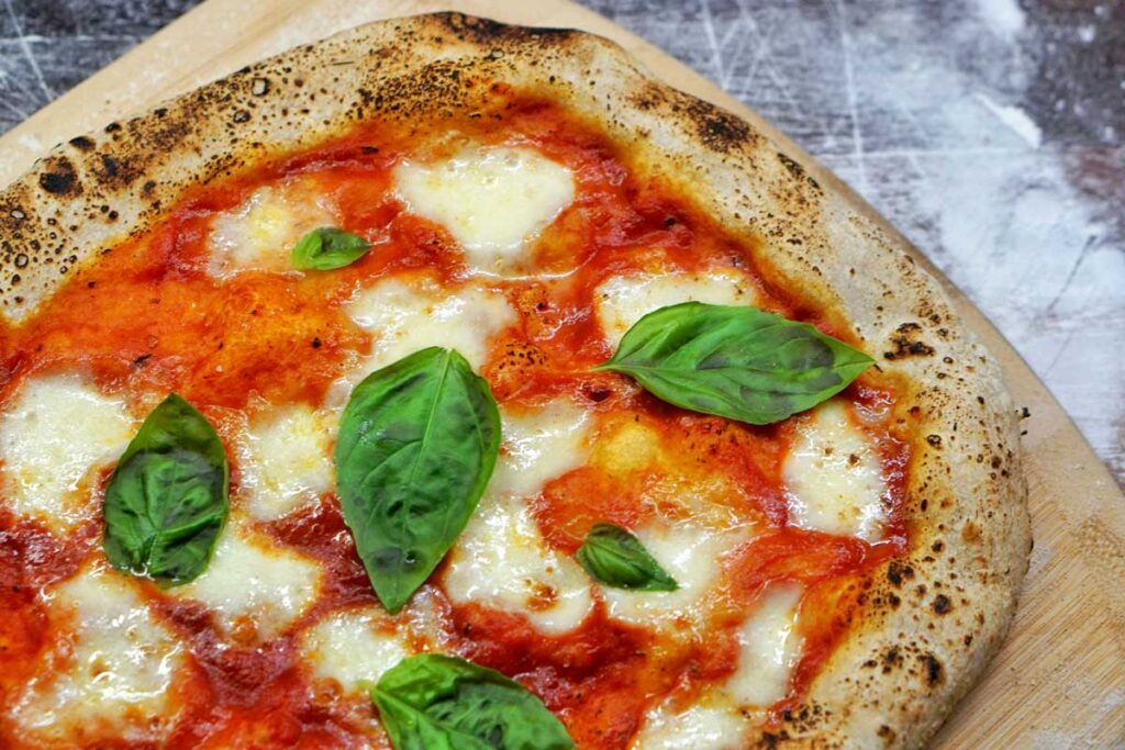 Original Pizza Margherita mit geschmolzenem Fior di Latte Mozzarella, Tomatensauce und frischem Basilikum – italienischer Klassiker mit Mozzarella.