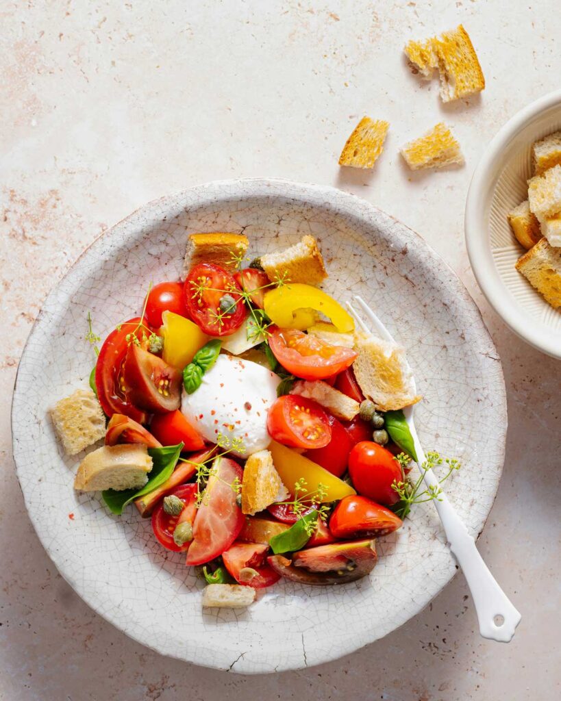Mediterraner Brotsalat mit frischem Mozzarella, Tomaten, Basilikum und Croutons – typisch italienische Rezeptidee mit Mozzarella.