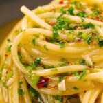 Großaufnahme von Spaghetti Aglio, Olio e Peperoncino mit Olivenöl und frischen Kräutern – authentisch, würzig und typisch italienisch.