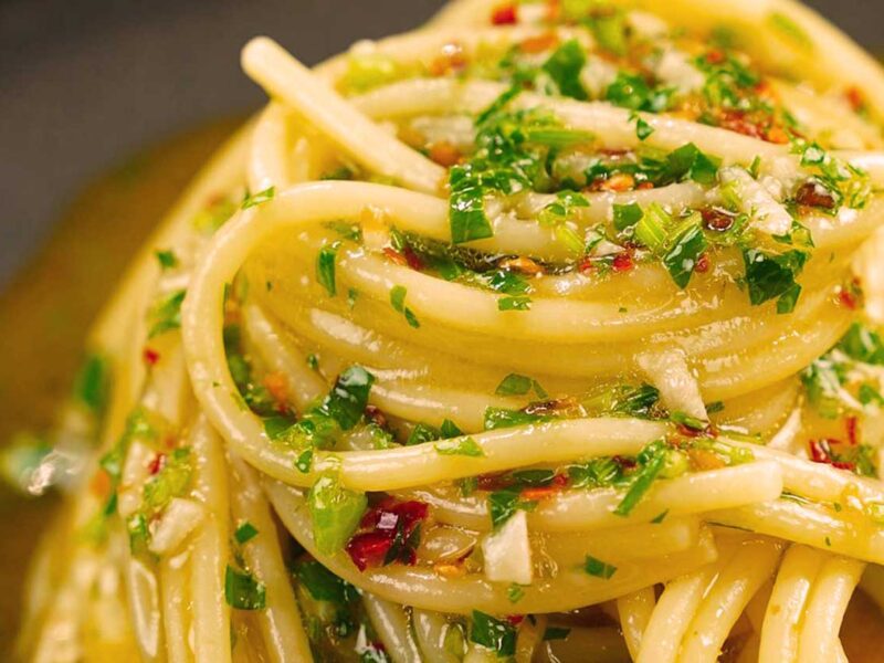 Großaufnahme von Spaghetti Aglio, Olio e Peperoncino mit Olivenöl und frischen Kräutern – authentisch, würzig und typisch italienisch.