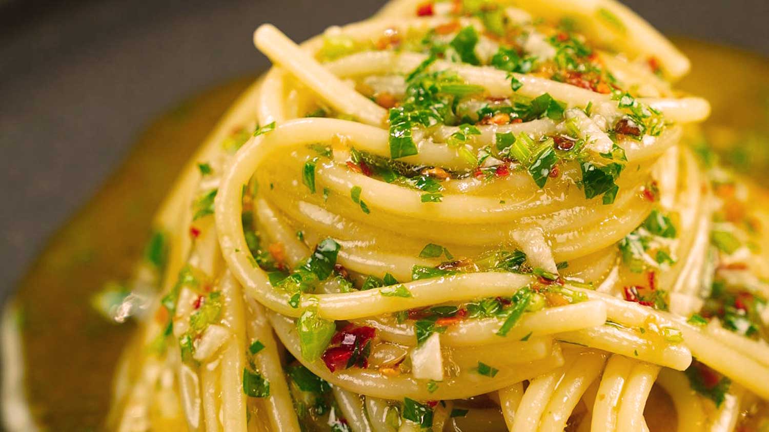 Großaufnahme von Spaghetti Aglio, Olio e Peperoncino mit Olivenöl und frischen Kräutern – authentisch, würzig und typisch italienisch.