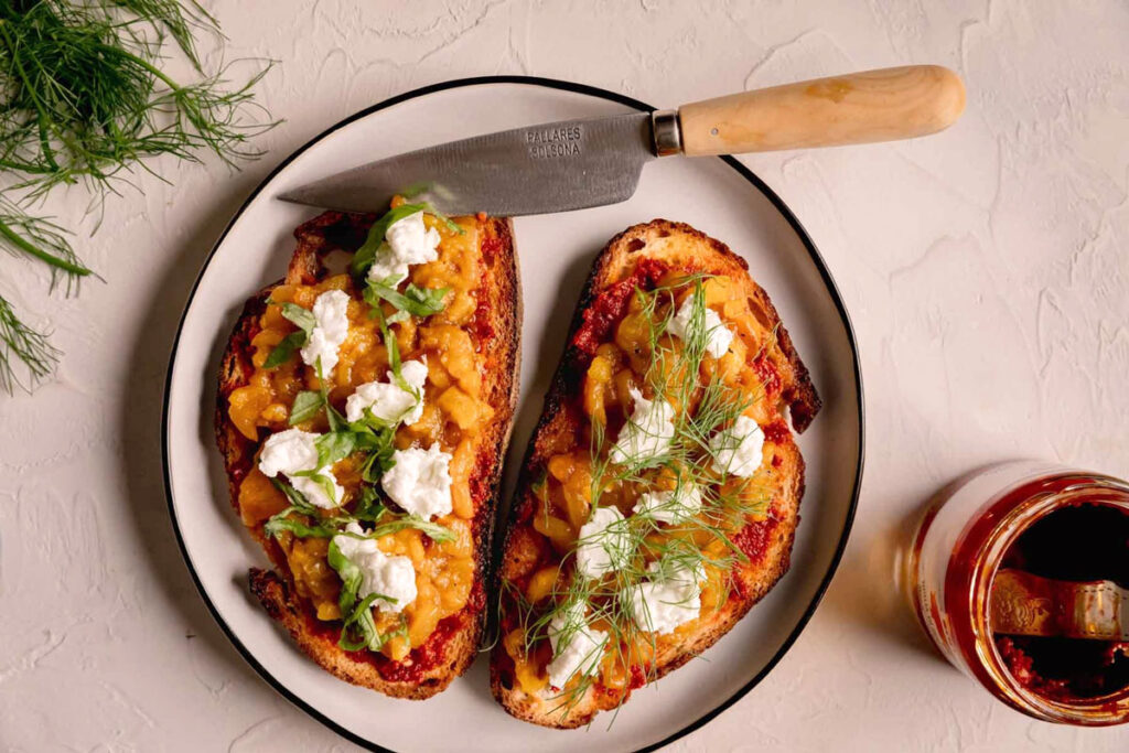 Geröstetes Brot mit ’Nduja-Aufstrich, geschmortem Gemüse und Ricotta, garniert mit frischen Kräutern – moderne Interpretation der kalabrischen Küche.