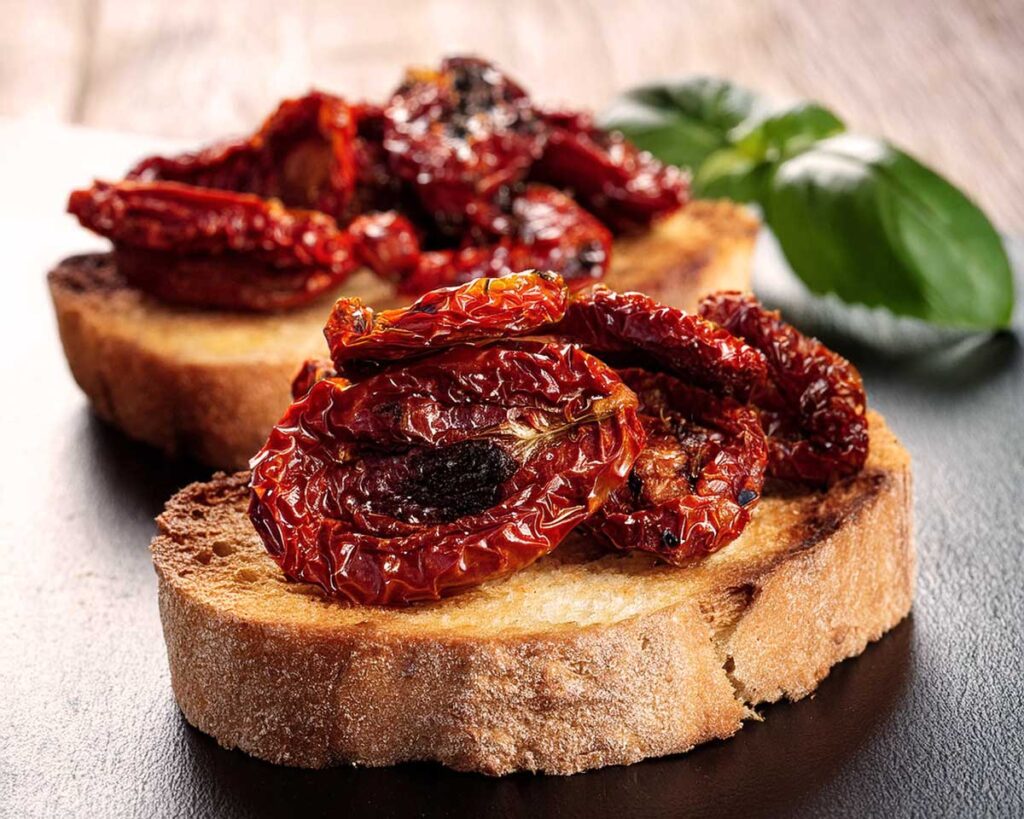 Knusprige Bruschetta mit aromatischen getrockneten Tomaten, angerichtet auf geröstetem Bauernbrot – perfekte Vorspeise aus der italienischen Küche.