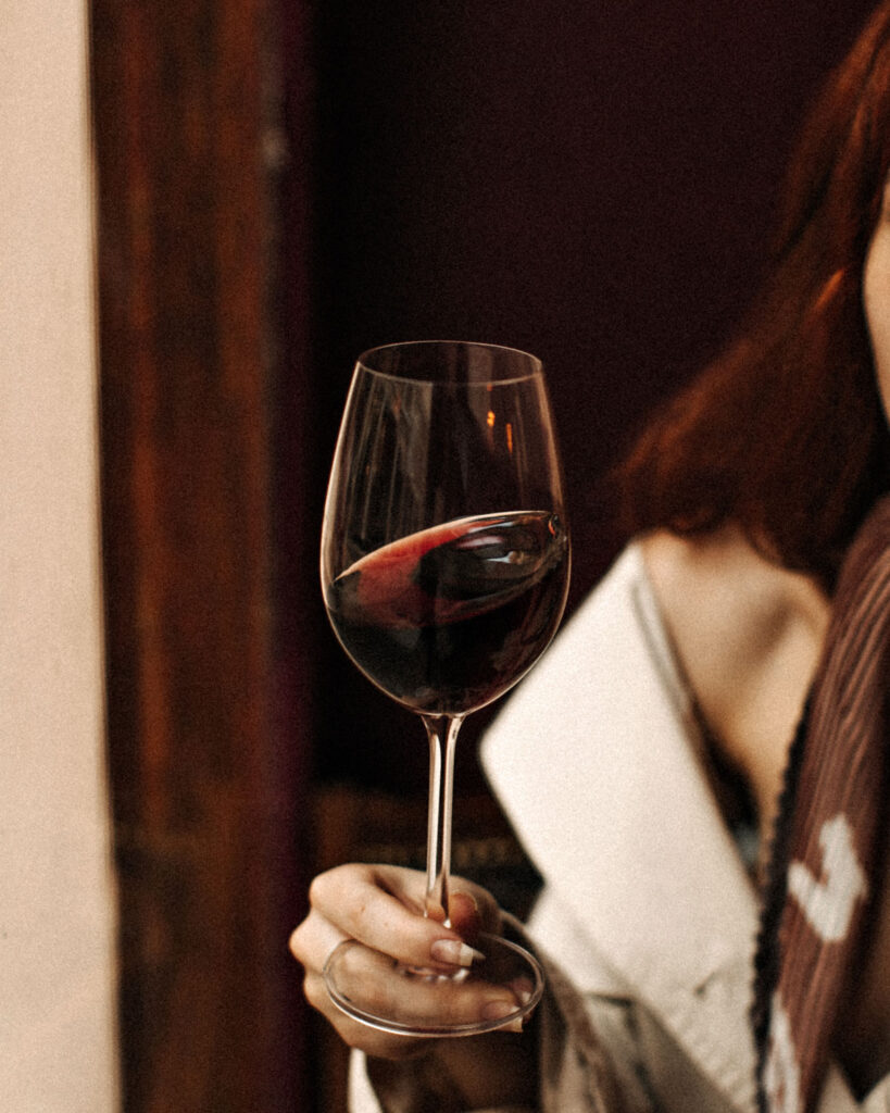 Frau hält ein Glas Amarone – eleganter Rotwein-Moment mit Stil.