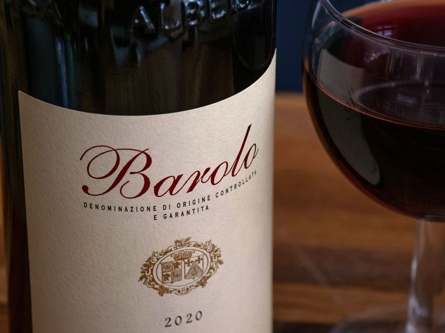 Edle Flasche Barolo DOCG 2020 neben einem Glas Rotwein – Symbol für die Regeln der idealen Speisen- und Weinbegleitung aus dem Piemont.