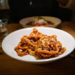 Leuchtend rote Amatriciana-Pasta mit Pecorino in gemütlicher Trattoria-Atmosphäre – ein italienisches Soulfood mit Geschichte.