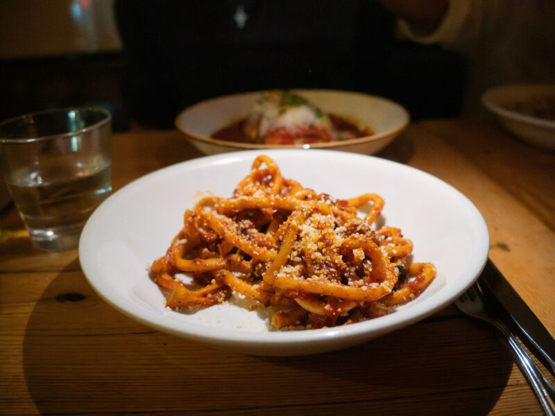 Leuchtend rote Amatriciana-Pasta mit Pecorino in gemütlicher Trattoria-Atmosphäre – ein italienisches Soulfood mit Geschichte.