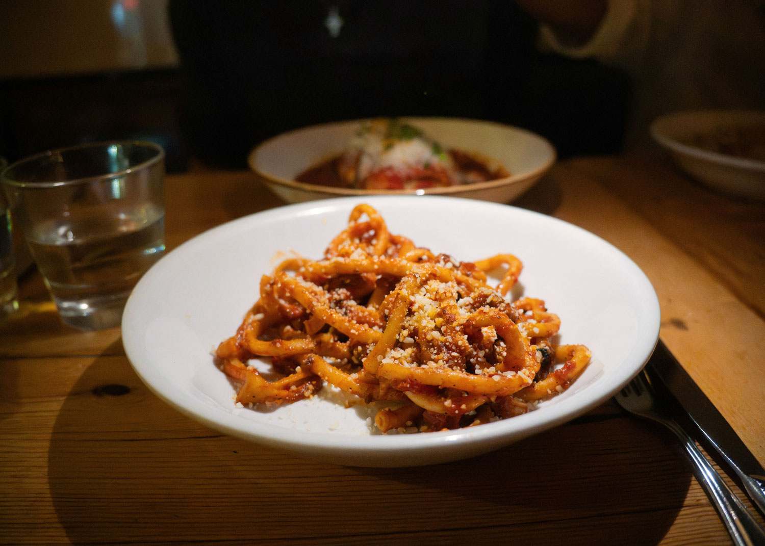 Leuchtend rote Amatriciana-Pasta mit Pecorino in gemütlicher Trattoria-Atmosphäre – ein italienisches Soulfood mit Geschichte.