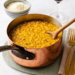 Kürbisrisotto in Kupfertopf mit Holzlöffel – herbstliches Gericht aus Italien, bereit zum Servieren