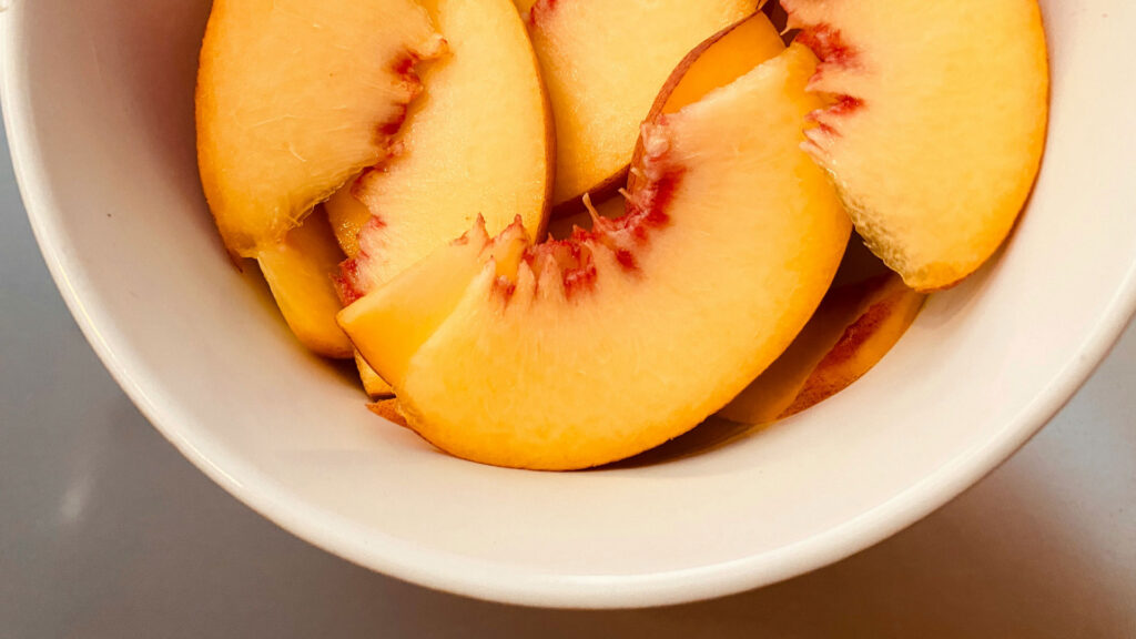 Reife italienische Pfirsichspalten – frisches Obst als Teil der mediterranen Ernährung, die nun zum UNESCO-Weltkulturerbe zählt