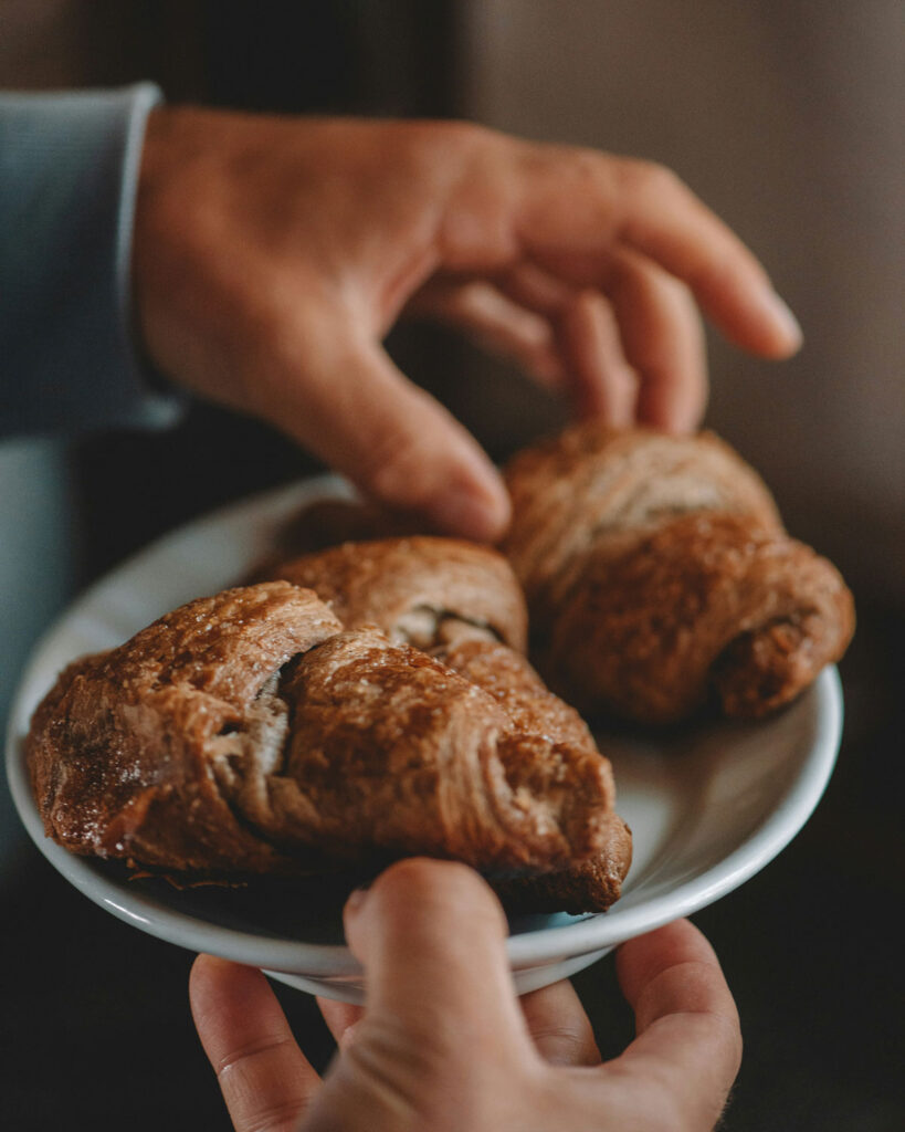 Schokoladen-Cornetti auf Teller – gefülltes italienisches Frühstücksgebäck mit Kakao.