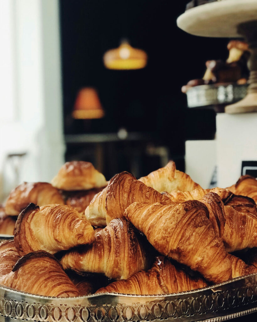 Mehrere frische Cornetti auf Tablett im Café – italienische Frühstückstradition.