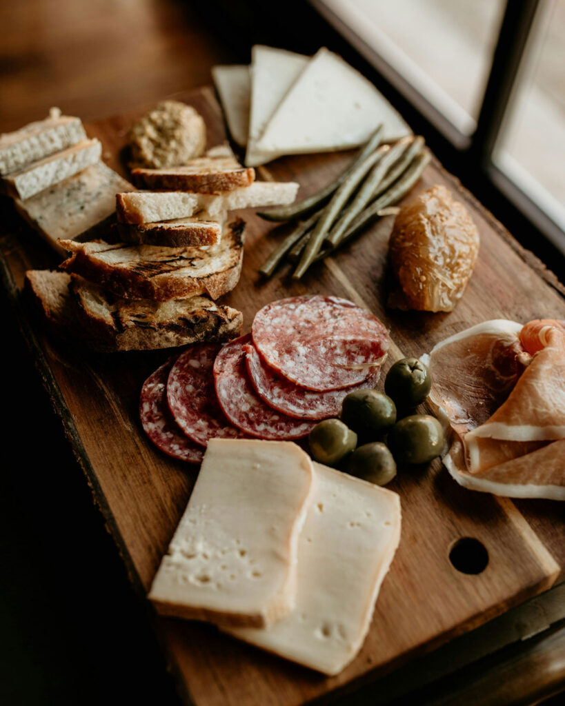 Italienisches Antipasti Brett mit Salami, Käse und Oliven – typische Feinkost Spezialitäten aus Italien