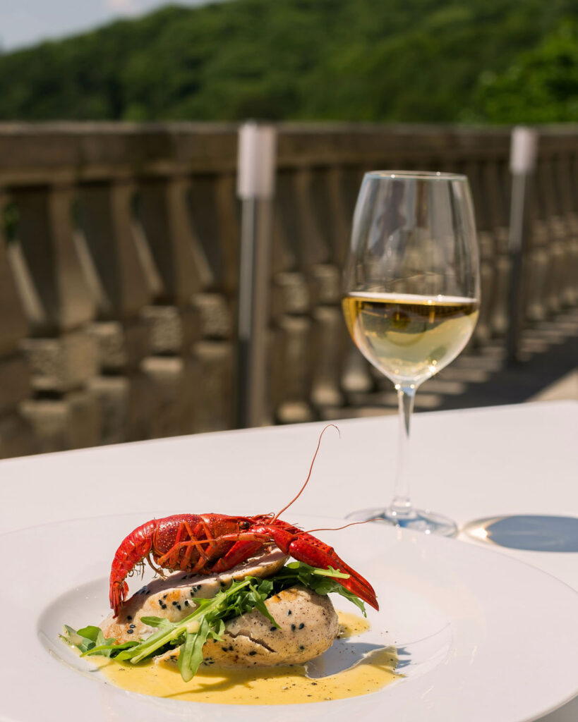 Gourmetgericht mit Hummer und Weißwein auf Terrasse – elegante Speisenbegleitung mit Weißburgunder (Pinot Bianco).
