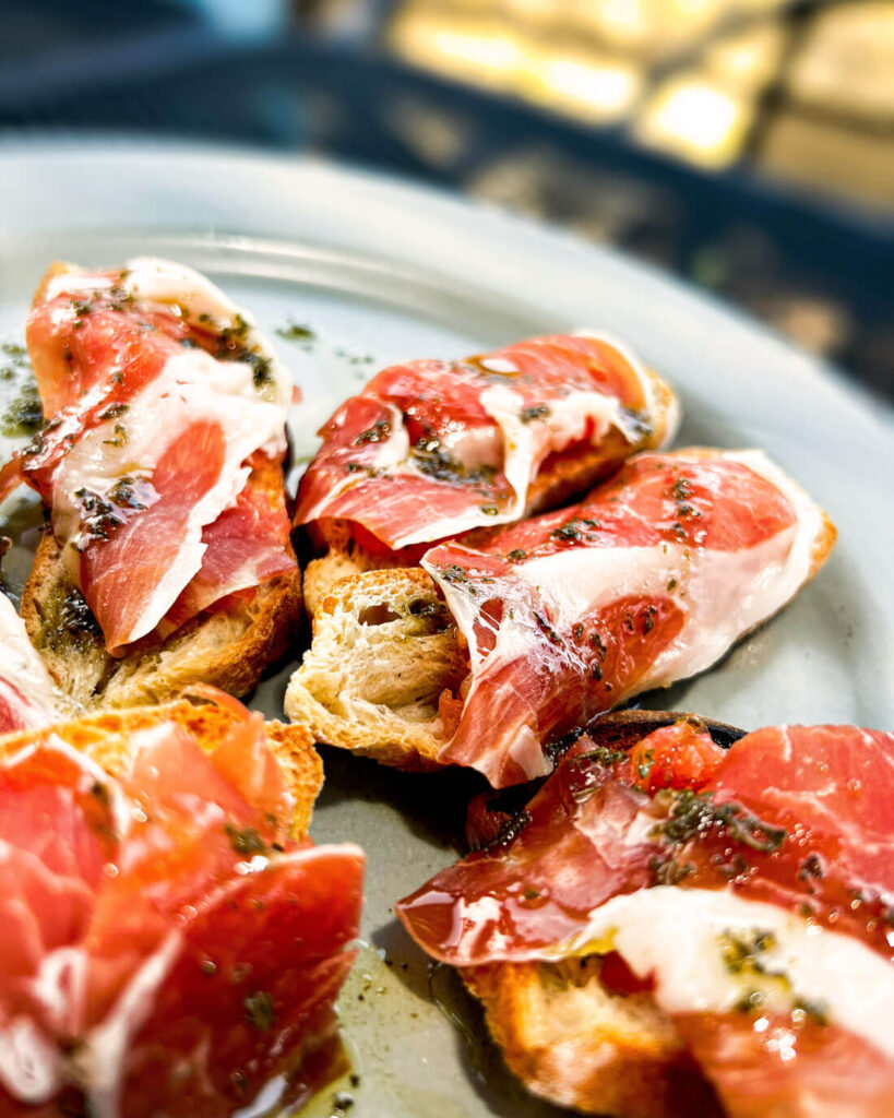 Gourmet Bruschetta mit Prosciutto – italienisches Antipasti mit luftgetrocknetem Schinken und Olivenöl