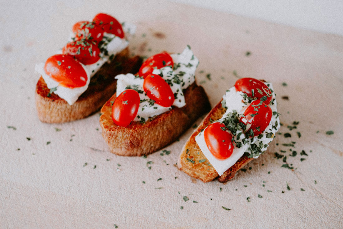 Bruschetta mit Tomaten und Käse – geröstetes Brot mit mediterranen Zutaten und frischen Kräutern