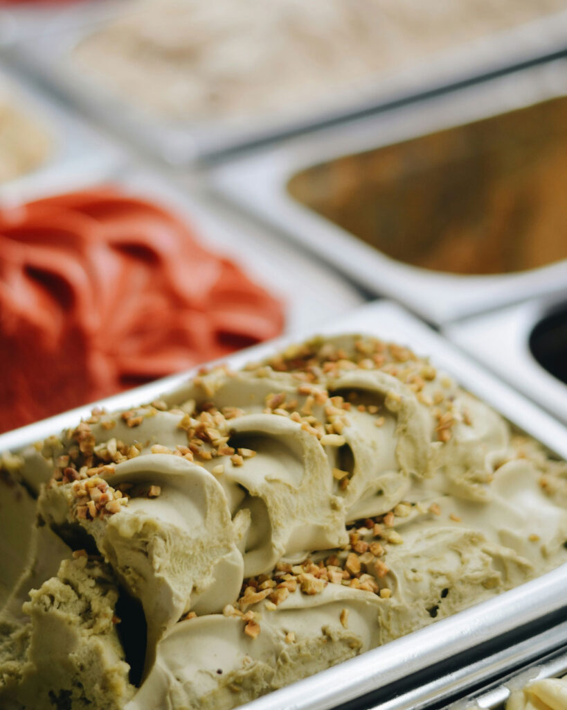 Pistazien-Gelato in der Eistheke – cremiges italienisches Pistazieneis mit gehackten Nüssen